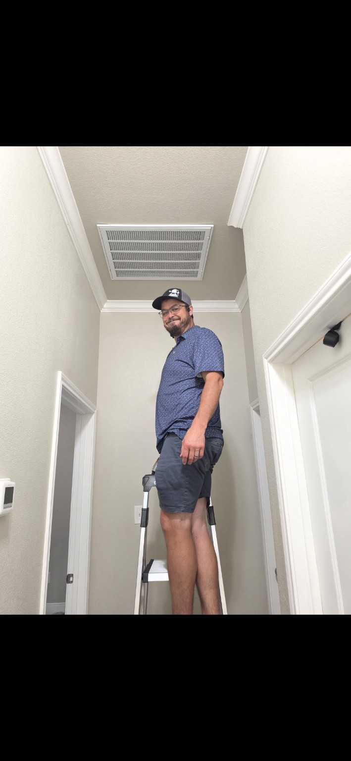 Scott Leany on a ladder inside a home